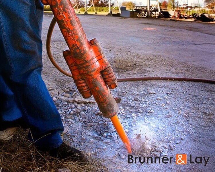 Close-up of Brunner and Lay concrete buster tool breaking through reinforced concrete on commercial construction project - Trusted Brunner and Lay dealer