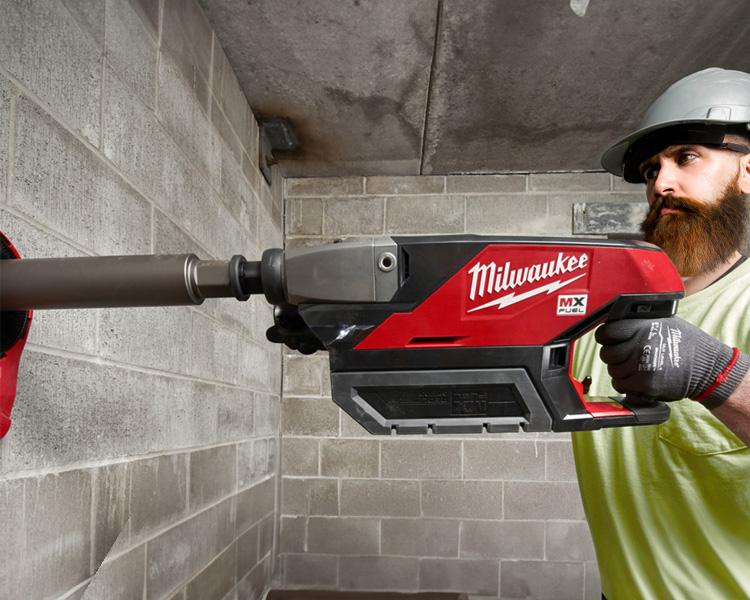 Construction worker using a Milwaukee drill to drill into concrete blocks, highlighting the tool's power and durability