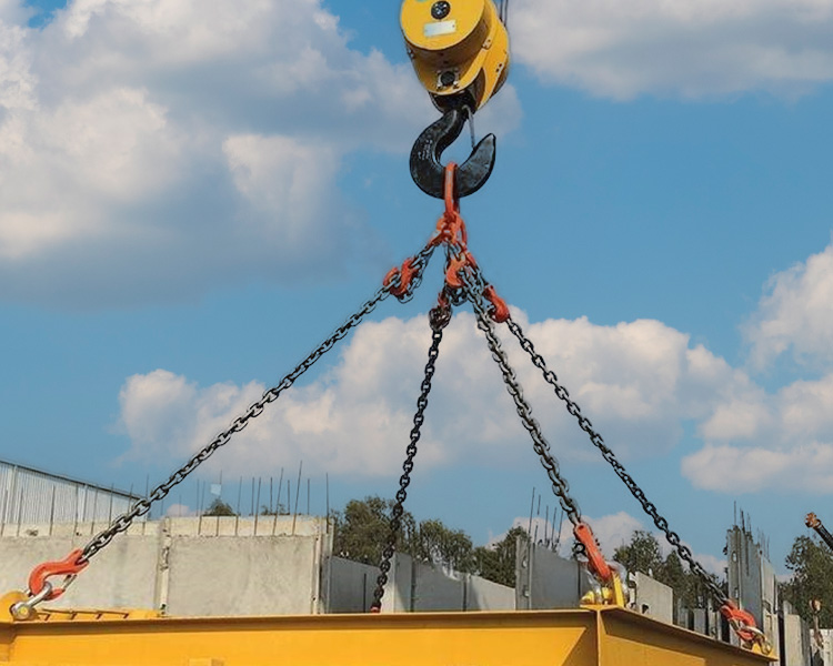 Heavy-duty rigging chain secured by a crane hook with clearly defined lifting points on a large steel structure